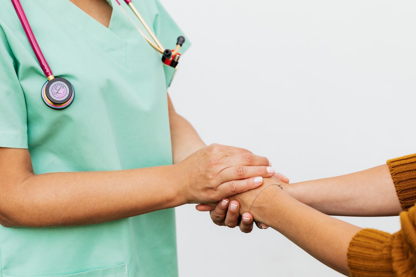A clinician gently holding a patient's hands